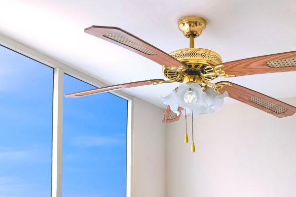 Vintage ceiling fan with electric lamps hanging on ceiling inside of white room Vintage ceiling fan with electric lamps hanging on ceiling inside of white room